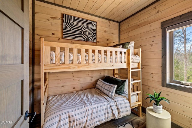 bedroom featuring multiple windows, wood ceiling, and wooden walls