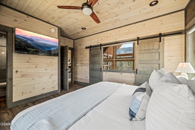 bedroom with wood ceiling, wood walls, a barn door, and wood finished floors