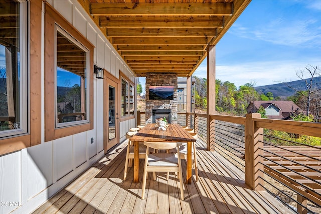 wooden deck featuring outdoor dining area and a mountain view