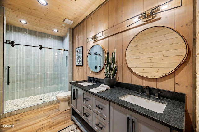 full bathroom with wood ceiling, wood walls, a shower stall, and a sink