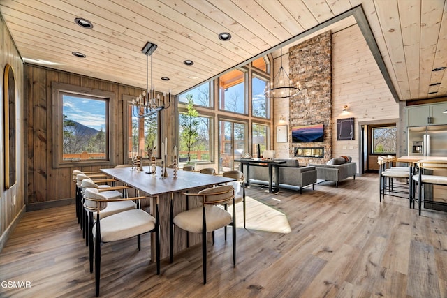 dining space featuring wooden walls, wooden ceiling, a wealth of natural light, and a notable chandelier