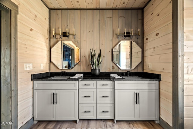 full bath featuring double vanity, wooden ceiling, wooden walls, and a sink