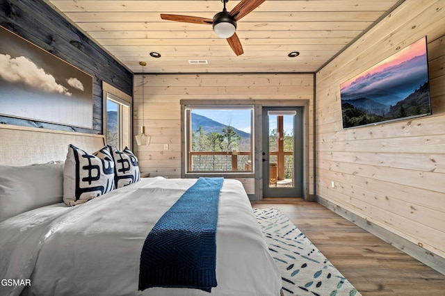 bedroom with access to outside, wood ceiling, wooden walls, and wood finished floors