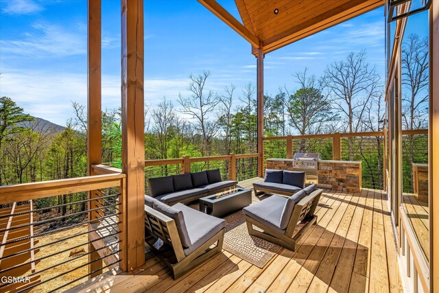 deck with a grill and an outdoor living space with a fire pit