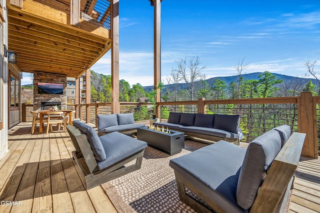 deck featuring an outdoor living space with a fire pit and a mountain view