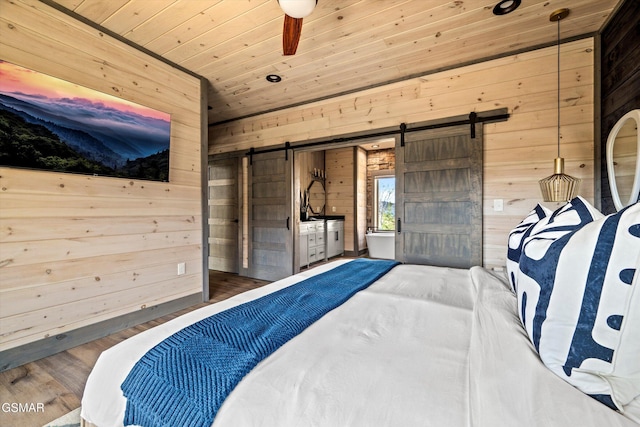 bedroom featuring wood finished floors, wood ceiling, wood walls, and a barn door