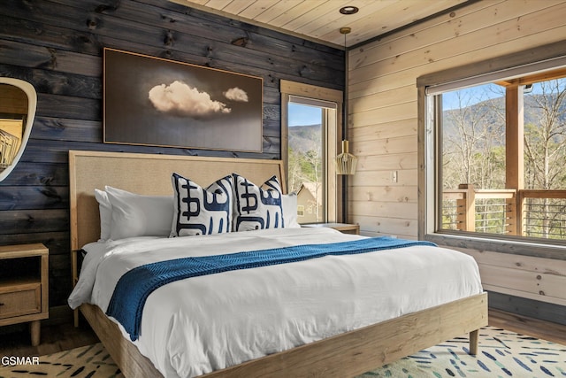 bedroom featuring wood ceiling, wooden walls, and wood finished floors