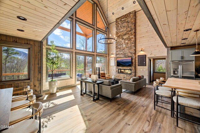 living room with high vaulted ceiling, wooden ceiling, wood walls, and wood finished floors