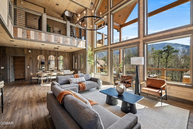 living room featuring wooden ceiling, a notable chandelier, wooden walls, and wood finished floors