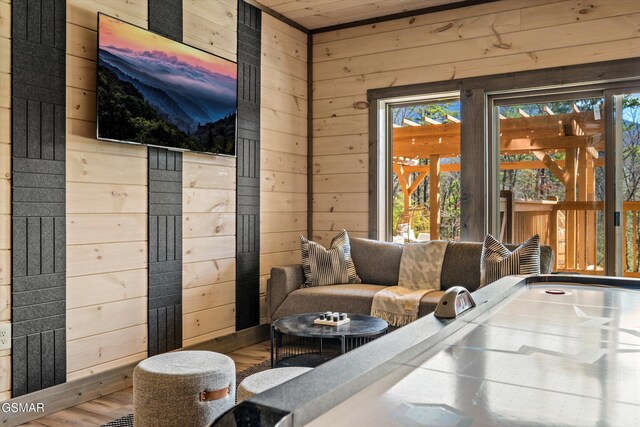 interior space featuring wooden walls, a wealth of natural light, and wood finished floors