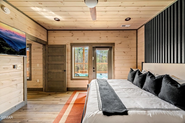 bedroom with access to exterior, light wood-type flooring, wooden ceiling, and wooden walls