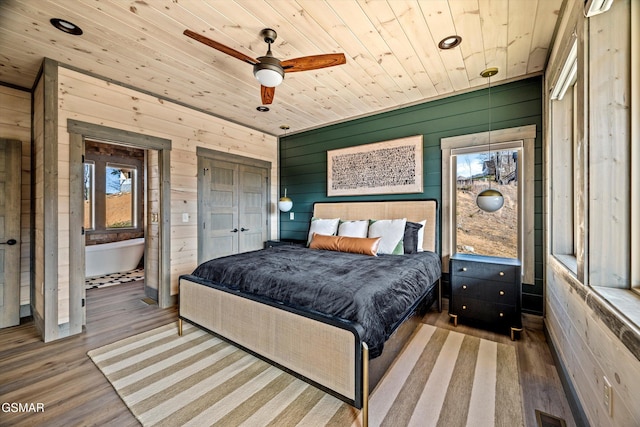 bedroom featuring visible vents, wood walls, wood finished floors, and wood ceiling