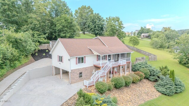 1110 Hide Away Ln, Kodak, TN 37764 - view of front of property with stairway, concrete driveway, brick siding, a sunroom, and roof with shingles
