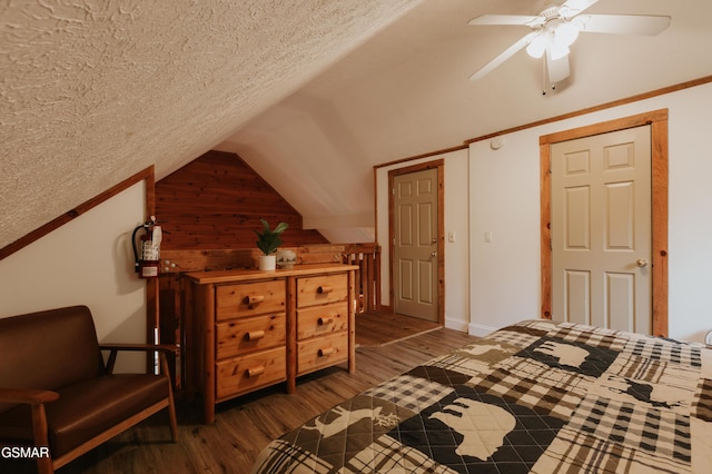 1730 Red Fox Ridge Way, Sevierville, TN 37862 - bedroom featuring vaulted ceiling, dark wood-style floors, a textured ceiling, a ceiling fan, and wooden walls