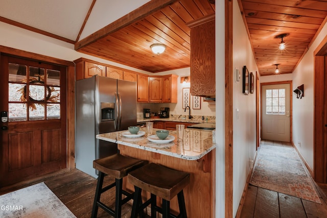 1730 Red Fox Ridge Way, Sevierville, TN 37862 - kitchen with stainless steel fridge with ice dispenser, dark wood finished floors, light stone counters, wooden ceiling, and a peninsula