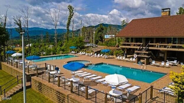 710 Village Loop Rd, Gatlinburg, TN 37738 - community pool featuring a jacuzzi, a mountain view, and a patio area