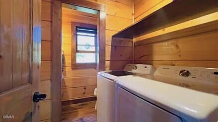 710 Village Loop Rd, Gatlinburg, TN 37738 - laundry area featuring separate washer and dryer, wood walls, and wood finished floors