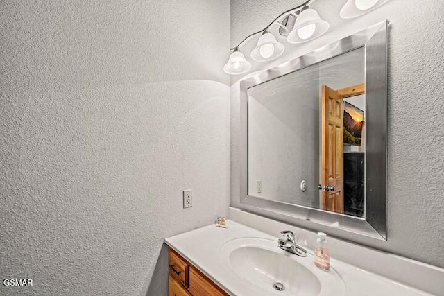 bathroom with vanity and a textured wall