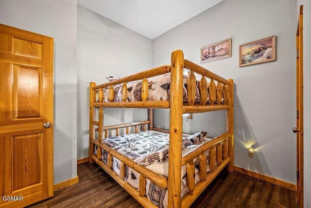 bedroom with baseboards and wood finished floors