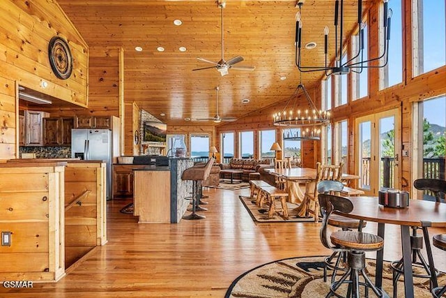 dining room featuring wood ceiling, a ceiling fan, high vaulted ceiling, and light wood-style flooring
