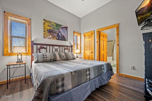 bedroom with baseboards, a textured wall, lofted ceiling, and wood finished floors