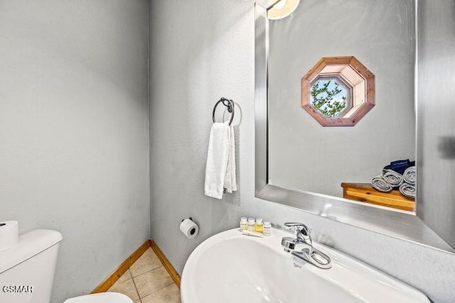 bathroom with a sink, tile patterned floors, and toilet