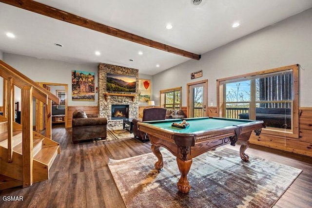 rec room featuring recessed lighting, beam ceiling, a stone fireplace, and wood finished floors