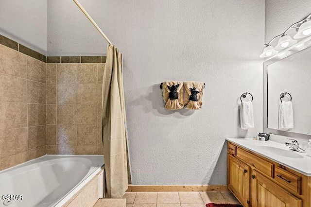 full bath with baseboards, tile patterned floors, tiled shower / bath combo, and vanity