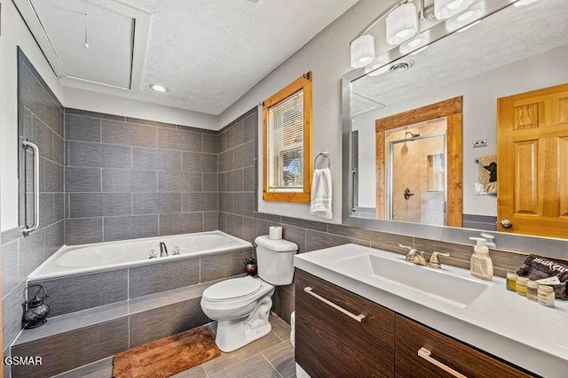 bathroom with tiled tub, tile walls, vanity, toilet, and recessed lighting