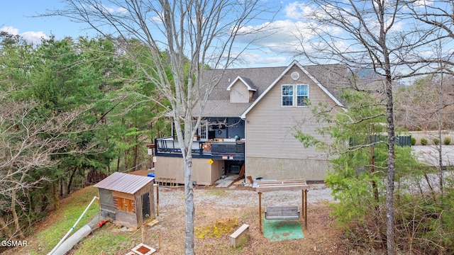 back of property with a deck and an outbuilding