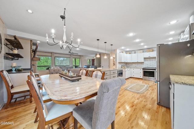 dining room featuring recessed lighting, light wood finished floors, beverage cooler, and a chandelier