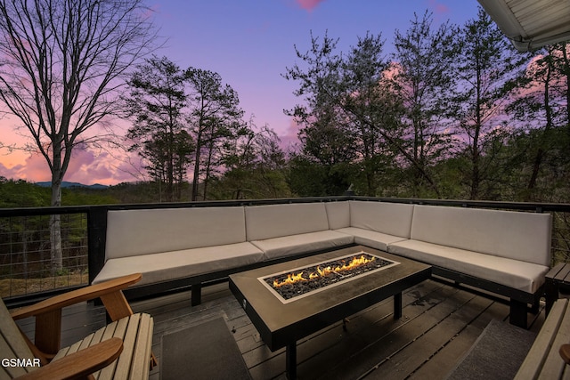 wooden terrace with an outdoor living space with a fire pit