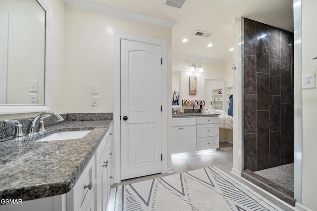 full bath featuring crown molding, tile patterned flooring, vanity, visible vents, and tiled shower