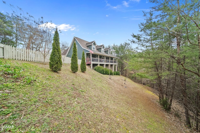 rear view of house with a sunroom and fence