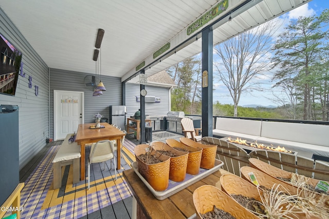 wooden deck featuring grilling area, a fire pit, and outdoor dining area