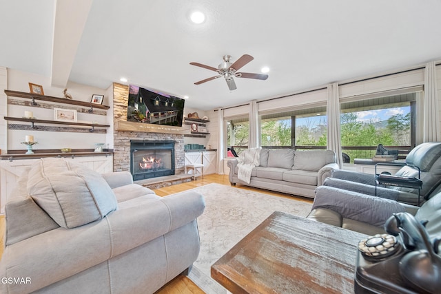 living area featuring light wood-style floors, ceiling fan, a fireplace, and recessed lighting