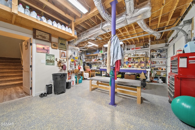 unfinished basement featuring stairway and a workshop area