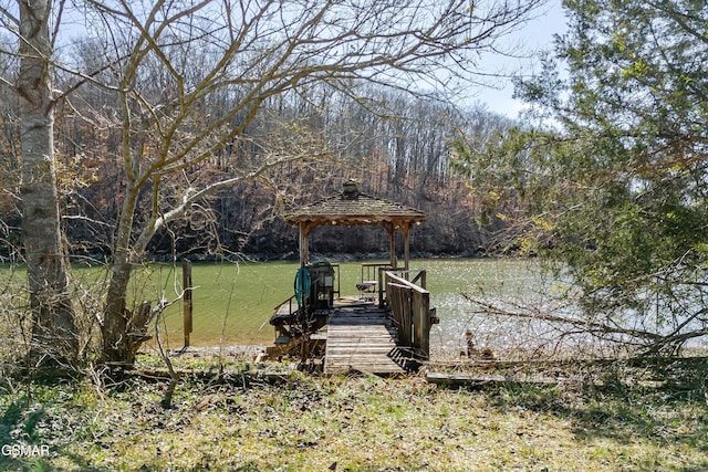 view of yard with a gazebo, a forest view, and a water view