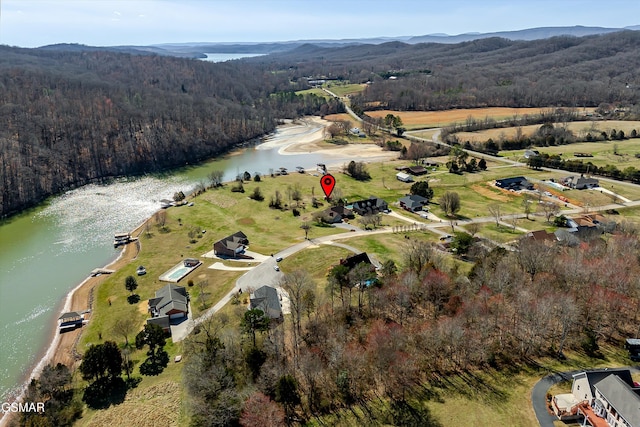 birds eye view of property featuring a forest view and a water view