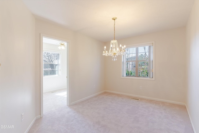 empty room with an inviting chandelier, baseboards, visible vents, and light carpet