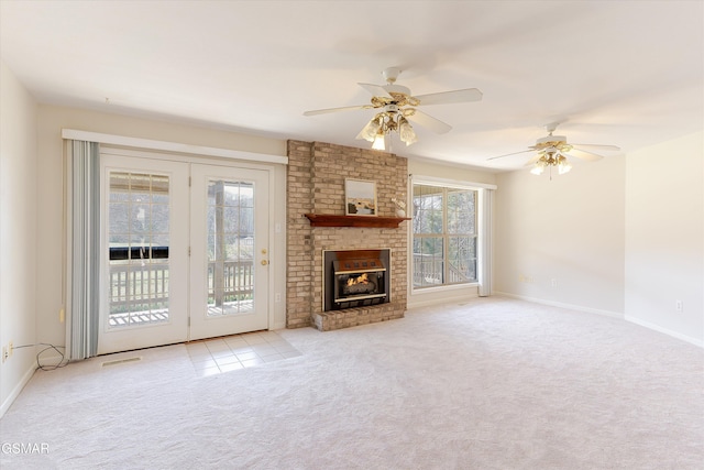 unfurnished living room with visible vents, ceiling fan, baseboards, carpet floors, and a fireplace