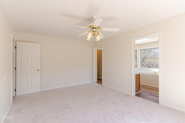 unfurnished bedroom with a ceiling fan, visible vents, baseboards, carpet floors, and ensuite bath