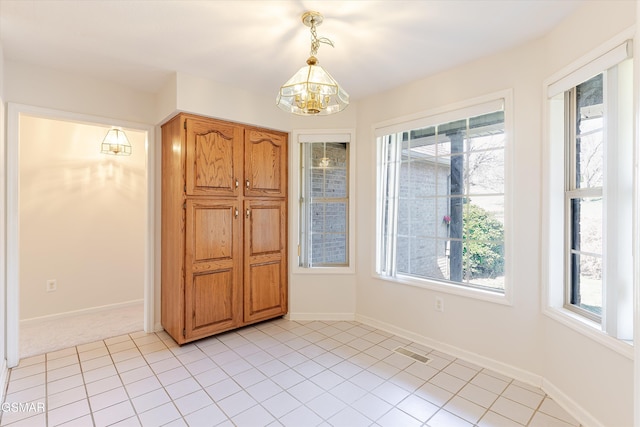 interior space featuring visible vents, plenty of natural light, baseboards, and a chandelier