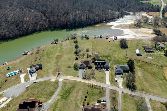 birds eye view of property featuring a wooded view and a water view