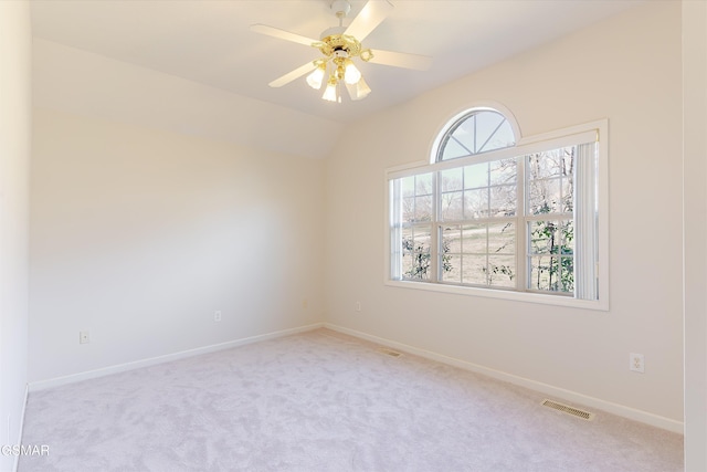 spare room with visible vents, lofted ceiling, carpet flooring, baseboards, and ceiling fan