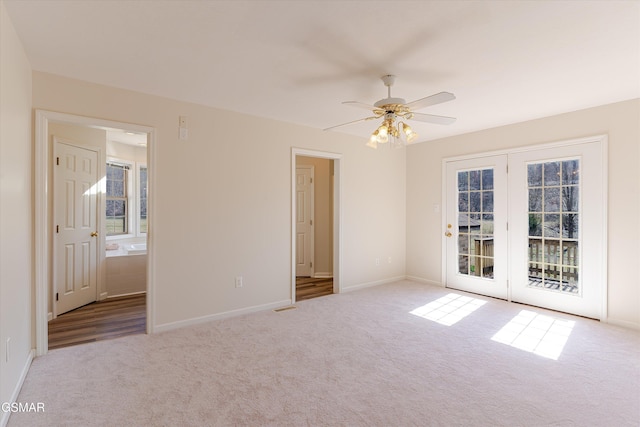 carpeted empty room with a healthy amount of sunlight, baseboards, and a ceiling fan