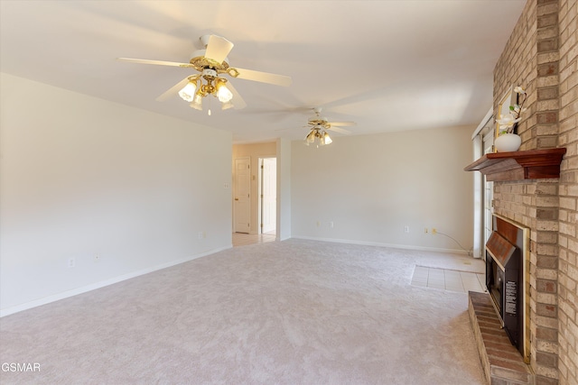 unfurnished living room with ceiling fan, a brick fireplace, baseboards, and carpet