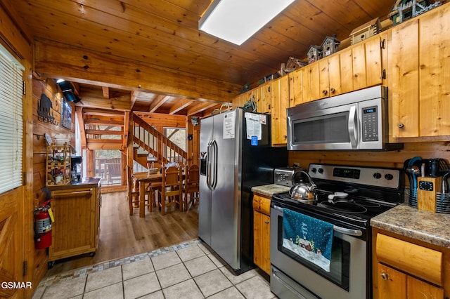 331 Caney Creek Rd, Pigeon Forge, TN 37863 - kitchen featuring appliances with stainless steel finishes, light tile patterned flooring, wood walls, and wood ceiling