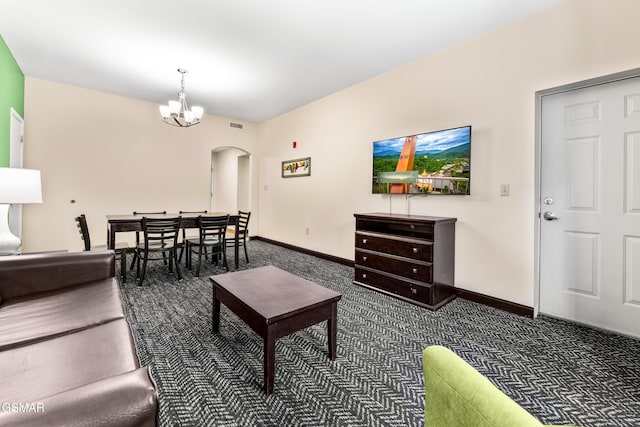 living room featuring a chandelier and dark colored carpet