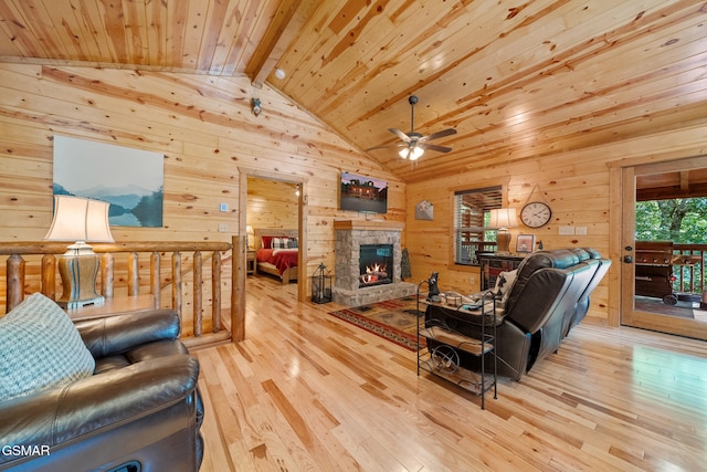 646 Stockton Dr, Sevierville, TN 37876 - living room with wooden walls, ceiling fan, wooden ceiling, hardwood / wood-style flooring, and a stone fireplace